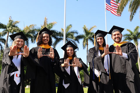 Diverse group of graduates waving the "U" symbol