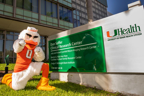 Sebastian the Ibis kneeling by the Don Soffer Clinical Research Center sign