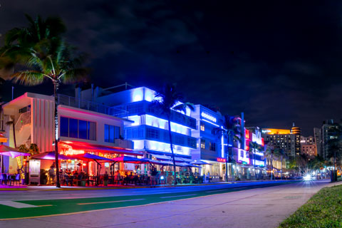 Night scene of lit buildings and street at Ocean Drive