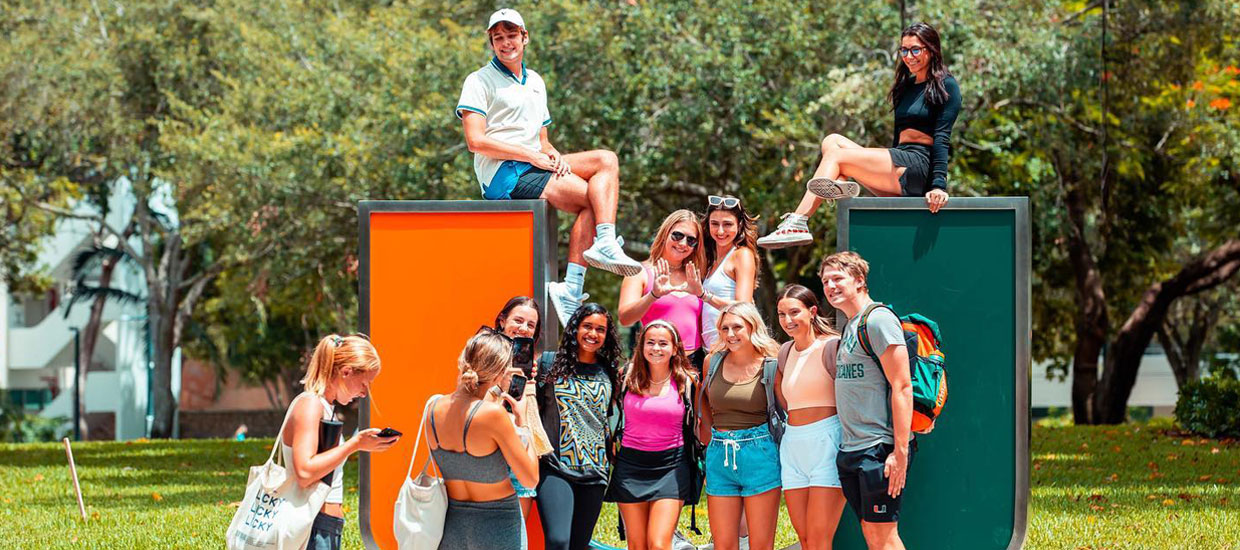 Students posing for photo with UM sculpture